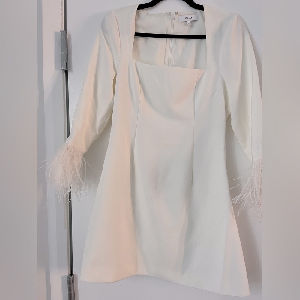 White dress, flattering fit, fun feather detail on sleeves